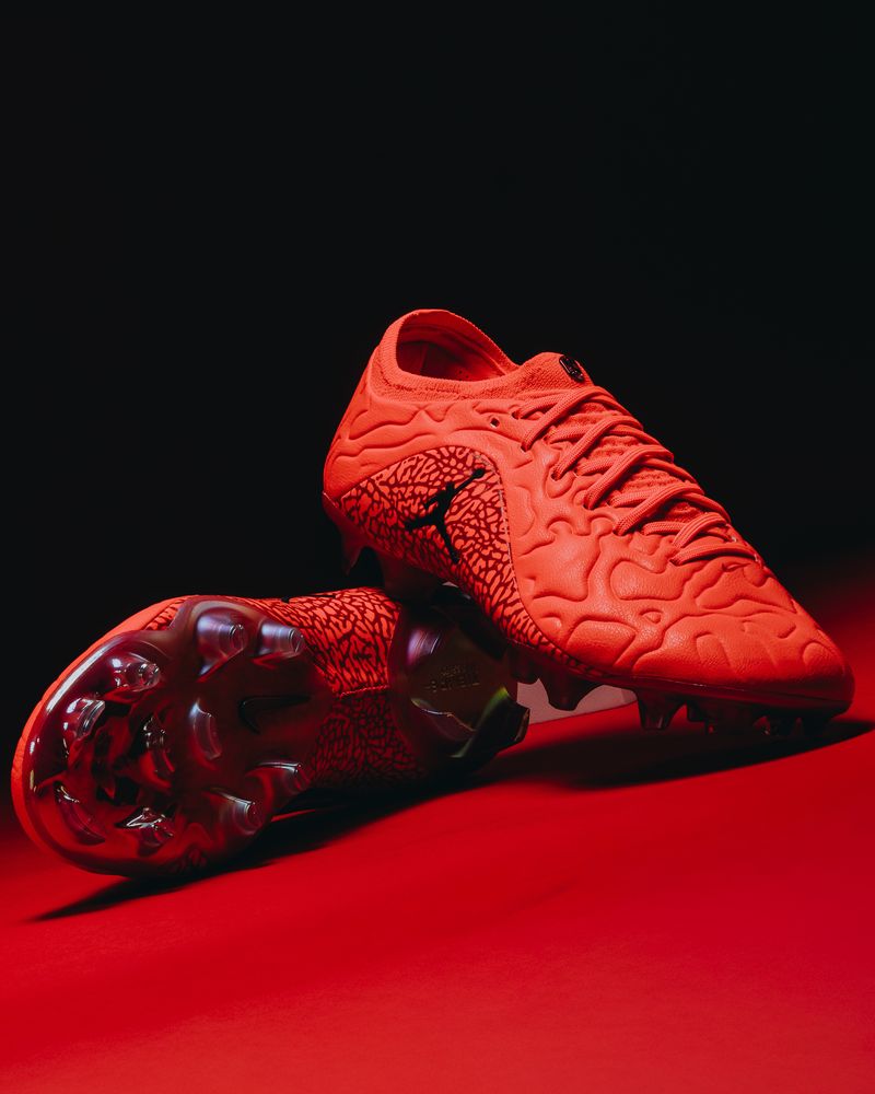The Nike Tiempo x Jordan SE pair on a red sweep, one boot showing the soleplate
